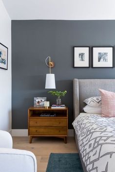 a bed room with a neatly made bed and two pictures on the wall above it