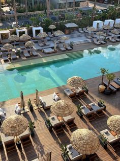 an aerial view of a hotel pool with lounge chairs and umbrellas