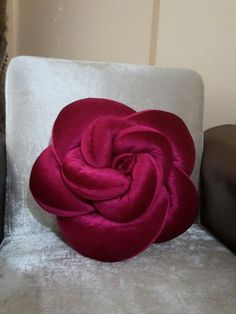 a red flower sitting on top of a white chair