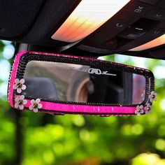 the rear view mirror of a car with flowers on it's side and pink trim