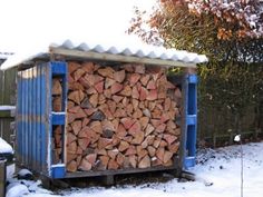 a large pile of wood sitting in the snow