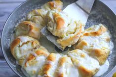 a pan filled with rolls covered in cheese