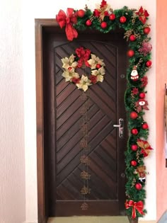 a door decorated with christmas wreaths and decorations