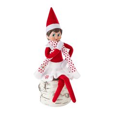 an elf doll sitting on top of a birch tree stump wearing a red and white polka dot dress