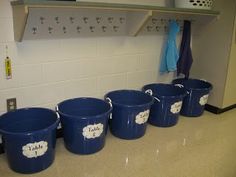 five blue buckets are lined up on the counter