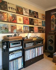 an entertainment center with record players, speakers and records on the wall in front of it