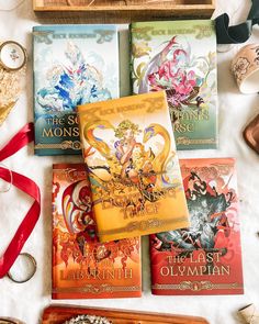 four books sitting on top of a table next to a clock and some other items