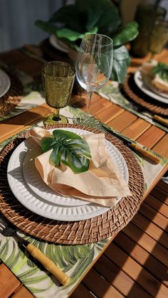 a table set with plates, napkins and wine glasses on top of the table