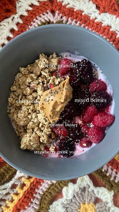 a bowl filled with granola and berries on top of a crocheted blanket