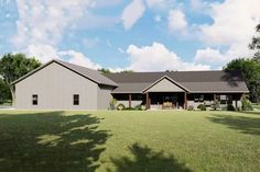 a large gray house sitting on top of a lush green field