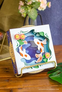 a card with two koi fish on it sitting on top of a wooden table