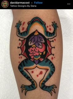 a colorful tattoo design on the leg of a person's leg, with an image of a frog holding a flower