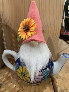 a gnome teapot with a sunflower on top