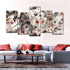 a living room with a couch, table and four pieces of playing cards on the wall