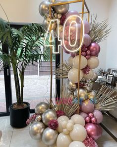 the balloon arch is decorated with pink, white and gold balloons that spell out forty