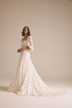 a woman in a white wedding dress with long sleeves and an open back is posing for the camera