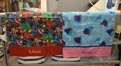 two personalized baby blankets on a rack in a room filled with other items and toys