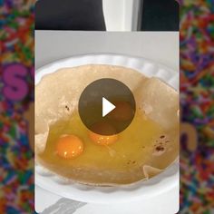 an egg burrito on a paper plate with a video play button in the middle