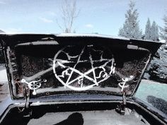 the back end of an old car with a pentagramus symbol on it's hood