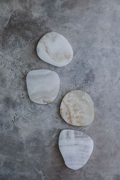 three pieces of marble sitting on top of a cement floor