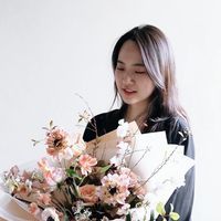 a woman holding a bouquet of flowers in her hands