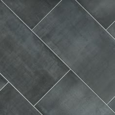 a close up view of a black tile floor with grey grouting on it