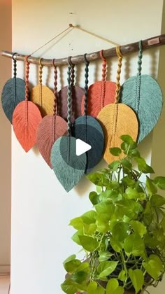 a potted plant sitting next to a wall hanging with heart shaped decorations on it