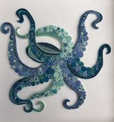 an octopus made out of buttons on a white surface with blue swirls and circles