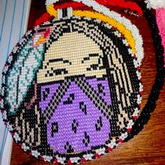 a close up of a beaded bag on a wooden surface with beads around it