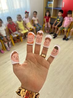 a person's hand with two fingernails that have faces on them