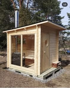 a small wooden cabin in the middle of a field with a hot tub and sauna