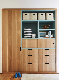 a wooden cabinet with drawers and shoes on the floor