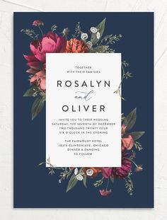 an elegant wedding card with flowers and leaves on the front, in navy blue background