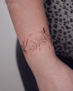 a woman's arm with a flower tattoo on the left side of her arm