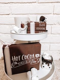 three tiered tray with coffee cups and other items on it, including a hot cocoa sign