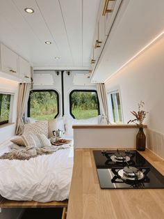 the interior of a camper with a bed and stove