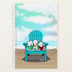 two white dogs sitting in a blue chair on the beach