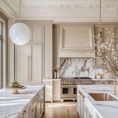 a large kitchen with marble counter tops and white cabinets, along with an island in the middle