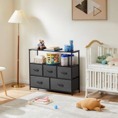 a baby's room with a crib, dresser and toy chest in it