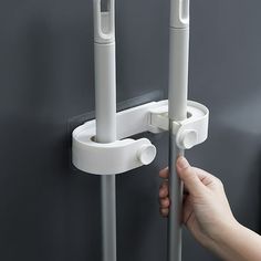 a hand is holding the handle on a door with two white handles and one black handle