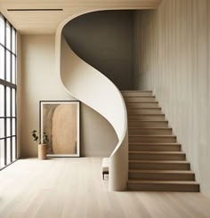 a spiral staircase in an empty room with large windows and potted plant next to it