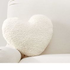 a heart shaped pillow sitting on top of a white couch