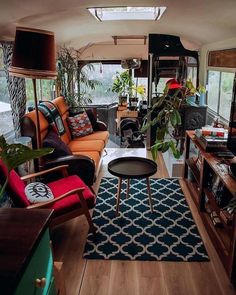 a living room filled with furniture and lots of plants on top of a wooden floor