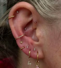 a close up of a person's ear with various piercings on it and one behind the ear