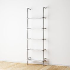 an empty white room with a metal shelving unit on the wall and wood flooring