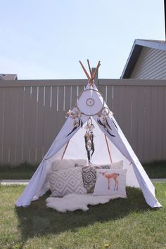 a teepee sitting on top of a lush green field