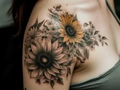 a woman's shoulder with sunflowers and leaves on it