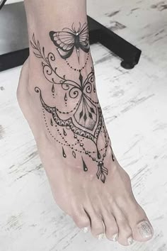 a woman's foot with a butterfly tattoo on it