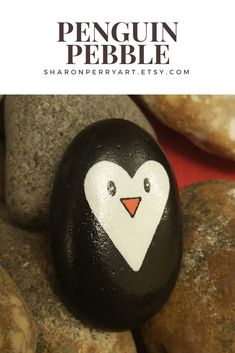 a penguin painted on top of rocks with the words penguin pebble written below it