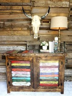 a cow skull mounted to the side of a wooden cabinet